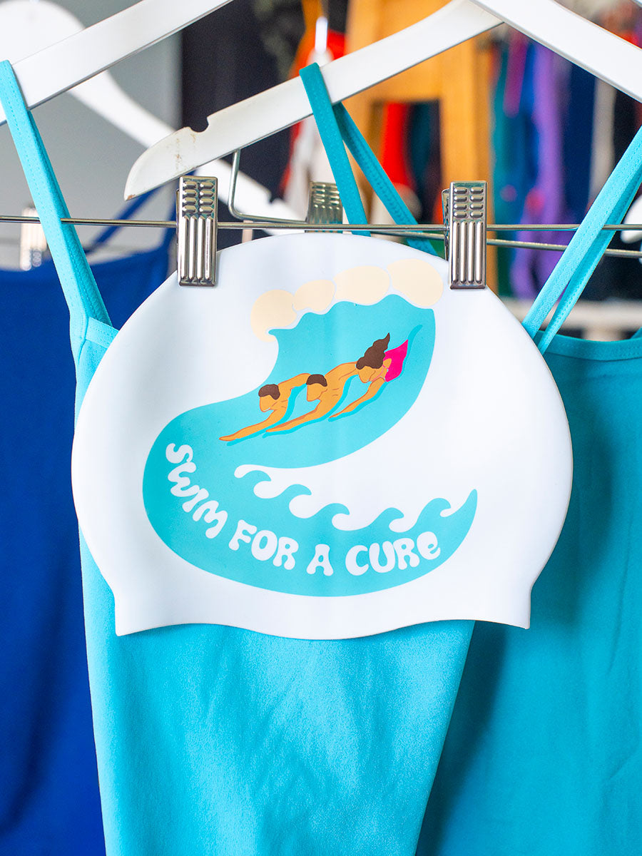 White Swimcap with 3 people body surfing and 'Swim for a cure' text.