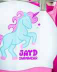 Blue and pink unicorn graphic on a white swim cap.