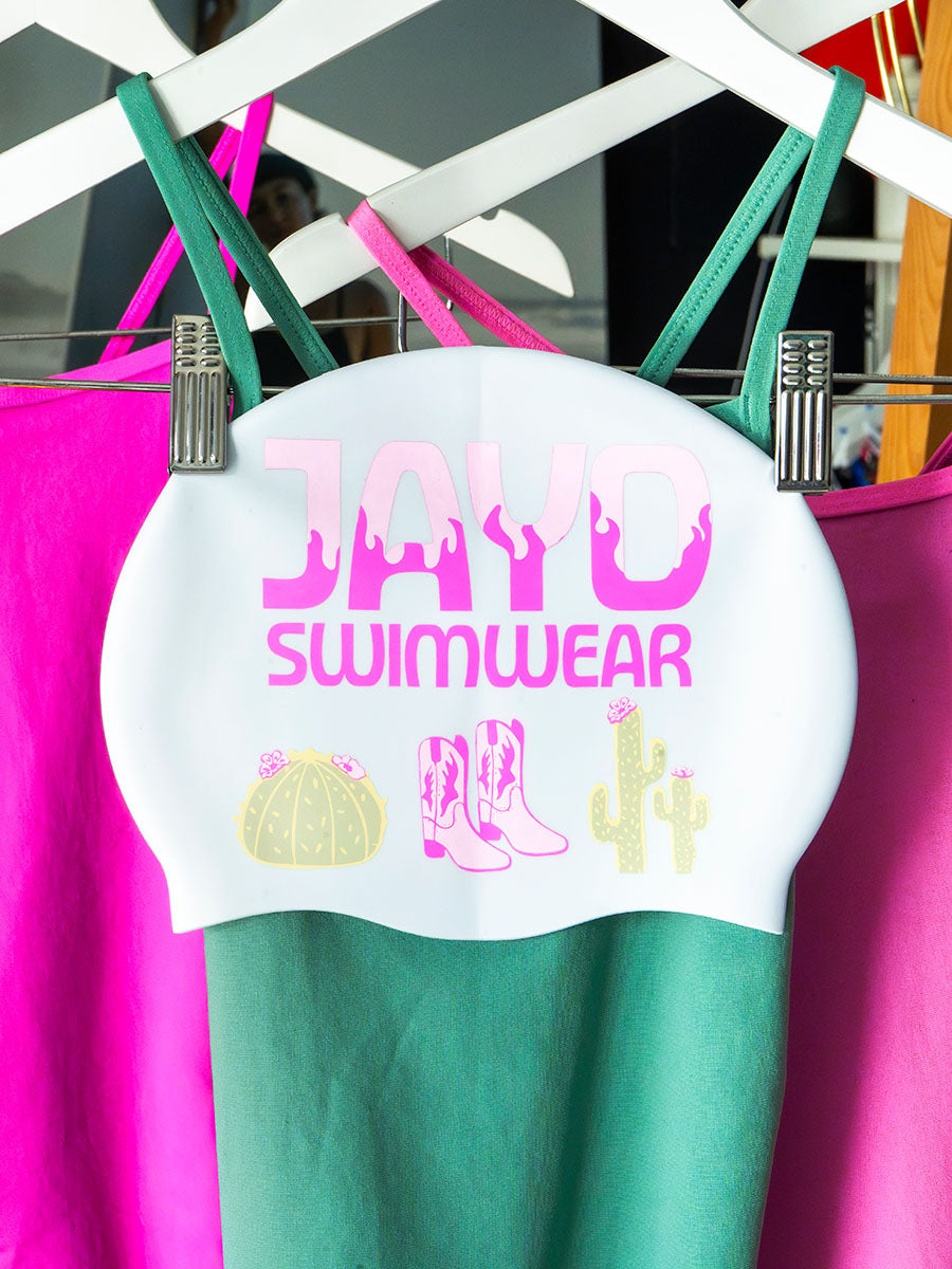 JAYD Swimwear white swim cap with cowboy boots and cactus illustrations.
