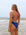 JAYD Swimwear model wearing the Zambia one piece swimsuit in navy with contrasting pink shoulder straps and canon back strap.