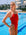 JAYD athlete Keira Stevens standing in front of a pool wearing the Zambia one piece swimsuit in Ruby with contrasting white shoulder straps and hip cut-outs.
