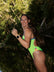 Athlete Jenaya wearing the JAYD Zambia One Piece in Splice green with Cancun blue shoulder straps and multi-coloured hip cut-outs with a rainforest and river in the background.