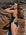Woman in a black Lennox fixed back one piece with Moss green straps standing against a rocky background