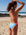 Woman in a breeze blue and contrasting vibe IBIZA one piece on a beach with ocean view